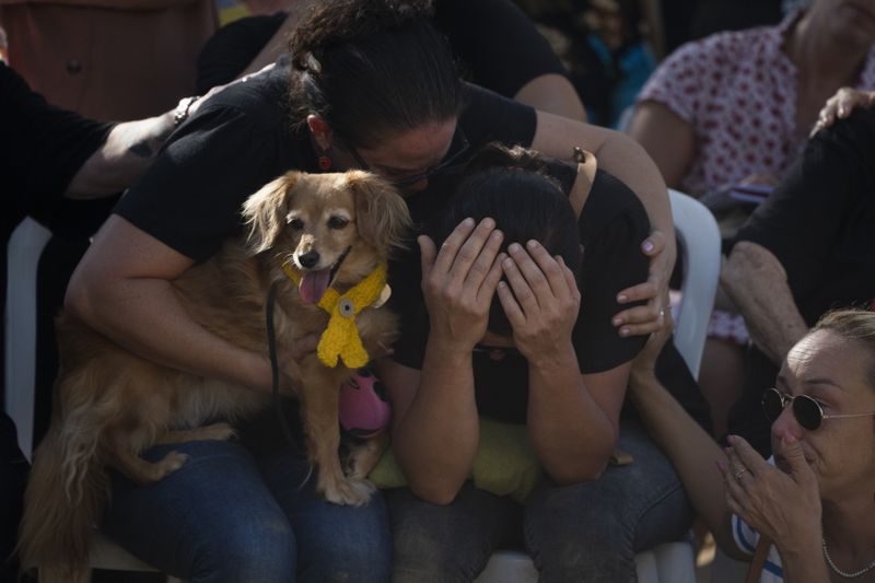 Rimon Buchshtab, center, mourns during the funeral of her husband Yagev Buchshtab at a cemetery of the kibbutz Nirim, southern Israel, Wednesday, Aug. 21, 2024. Buchshtab's body was one the six bodies of hostages, taken in Hamas' Oct. 7 attack, recovered by Israel's military during an operation in the Gaza Strip. (AP Photo/Leo Correa)