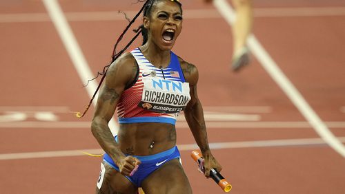 FILE - Sha'Carri Richardson, of the United States, celebrates after she crosses the finish line to anchor her team to gold in the Women's 4x100-meters relay final during the World Athletics Championships in Budapest, Hungary, Aug. 26, 2023. There is one more item to scratch off the list before everyone from Richardson to Noah Lyles to Sydney McLaughlin-Levrone embark on their trips to Paris for the Olympics: Making the Olympic team. US track trials start Friday, June21, 2024. (AP Photo/Martin Meissner, File)