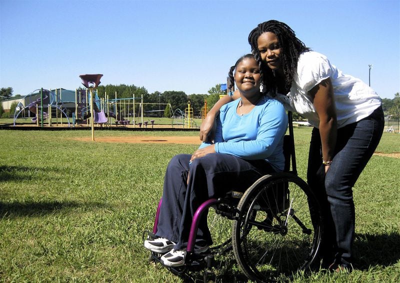 Anaiah Rucker and her mom, Andrea Taylor, are shown at Morgan County Elementary School, shortly after she had her left leg amputated in 2011 following an incident where she pushed her younger sister out of the way of an oncoming truck. (Jennifer Brett / AJC file photo)