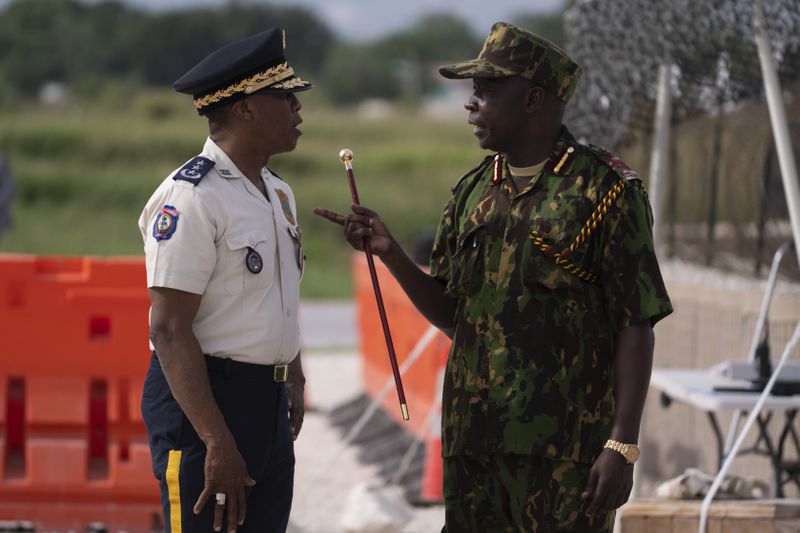 The commander of the Multinational Security Support (MSS) mission Godfrey Otunge, right, and the Haitian National Police general director Rameau Normil chat as they await the arrival of U.S. Secretary of State Antony Blinken in Port-au-Prince, Haiti, Thursday, Sept. 5, 2024. (Roberto Schmidt/Pool photo via AP)