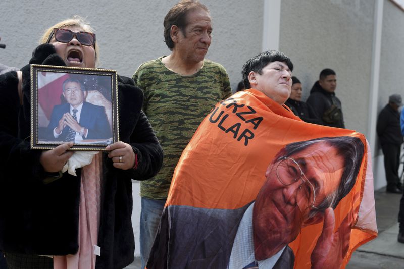 Supporters of former President Alberto Fujimori gather outside the home of his daughter Keiko, the day after he died in Lima, Peru, Thursday, Sept. 12, 2024. (AP Photo/Guadalupe Pardo)