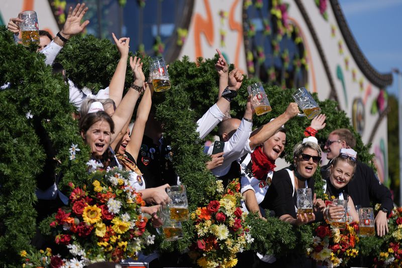 The Oktoberfest hosts arrive for the start of the 189th 'Oktoberfest' beer festival in Munich, Germany, Saturday, Sept. 21, 2024. (AP Photo/Matthias Schrader)