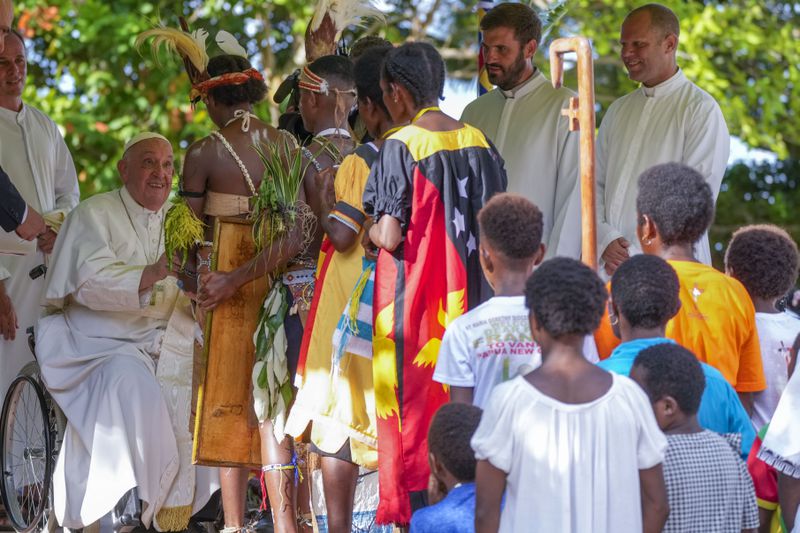 Pope Francis, left, meets with indigenous people at the Holy Trinity Humanistic School in Baro, near Vanimo, Papua New Guinea, Sunday, Sept. 8, 2024. Despite the considerable security concerns of entering a region torn by tribal rivalries, Francis seemed to relish the jungle visit, perhaps because he felt so much at home. A dozen Argentine missionary priests and nuns have lived in Vanimo with the local community for years and had invited him to come. (AP Photo/Gregorio Borgia)