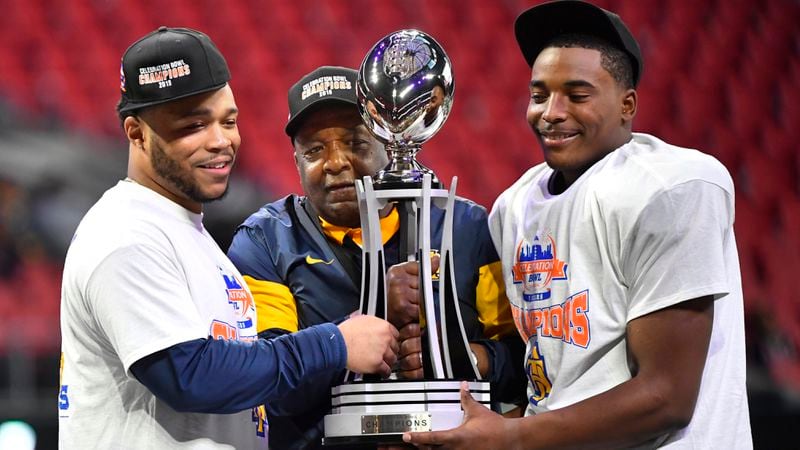 North Carolina A&T quarterback and offensive player of the game Kylil Carter (left), coach Sam Washington and defensive player of the game linebacker Jacob Roberts (right) hold the trophy after winning the Celebration Bowl Saturday, Dec. 21, 2019, at Mercedes-Benz Stadium in Atlanta.