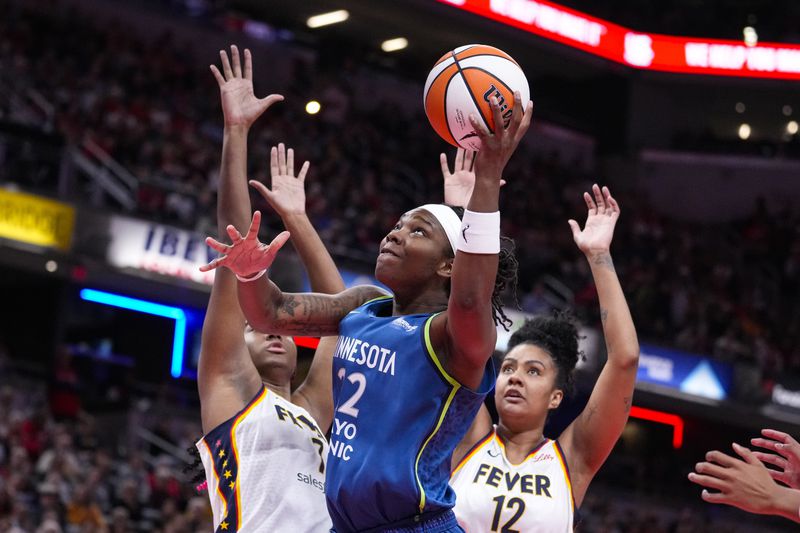 Minnesota Lynx forward Myisha Hines-Allen (22) shoots in front of Indiana Fever forward Aliyah Boston (7) and forward Damiris Dantas (12) in the first half of a WNBA basketball game in Indianapolis, Friday, Sept. 6, 2024. (AP Photo/Michael Conroy)