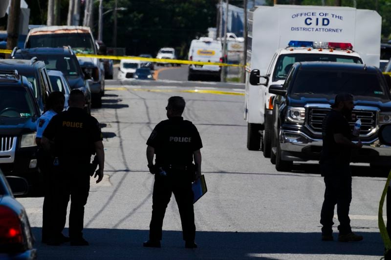 Law enforcement stand at the scene of a fatal shooting at Delaware County Linen, Wednesday, May 22, 2024, in Chester, Pa., a Philadelphia suburb. (AP Photo/Matt Rourke)