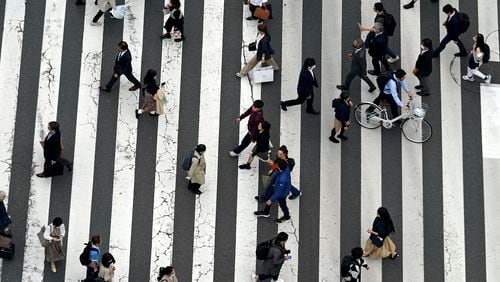 FILE - People walk along a pedestrian crossing at Ginza shopping street in Tokyo, on March 31, 2023, in Tokyo. (AP Photo/Eugene Hoshiko, File)