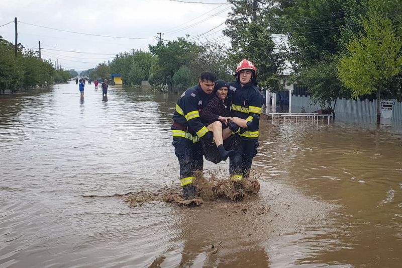 In this photo released by the Romanian Emergency Services Galati (ISU Galati), rescuers carry a woman in Pechea, Romania, Saturday, Sept. 14, 2024 after torrential rainstorms left scores of people stranded in flooded areas. (Romanian Emergency Services - ISU Galati via AP)