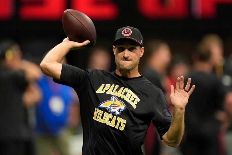 Atlanta Falcons quarterback Kirk Cousins warms up, while wearing an Apalachee High School T-shirt following a recent school shooting there, before an NFL football game against the Pittsburgh Steelers on Sunday, Sept. 8, 2024, in Atlanta. (AP Photo/John Bazemore)