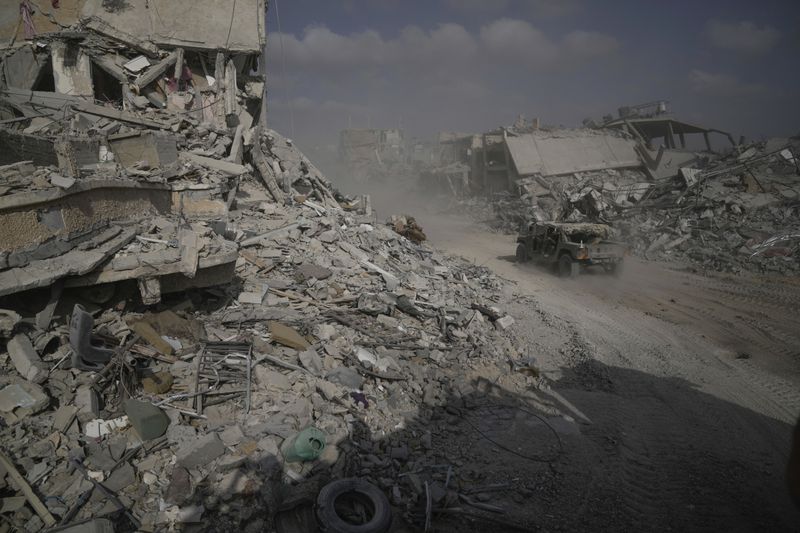 Israeli soldiers drive next to destroyed buildings following Israeli strikes during a ground operation in the Gaza Strip on Friday, Sept. 13, 2024. (AP Photo/Leo Correa)