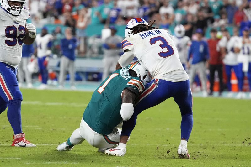 Miami Dolphins quarterback Tua Tagovailoa (1) collides with Buffalo Bills safety Damar Hamlin (3) during the second half of an NFL football game, Thursday, Sept. 12, 2024, in Miami Gardens, Fla. Tagovailoa was injured on the play. (AP Photo/Rebecca Blackwell)