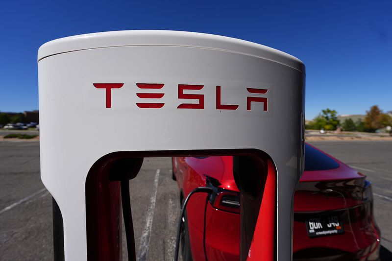 FILE - A Tesla Model 3 charges at a Tesla supercharging station situated in the parking lot of an outlet mall Sept. 25, 2024, in Lakewood, Colo. (AP Photo/David Zalubowski, File)