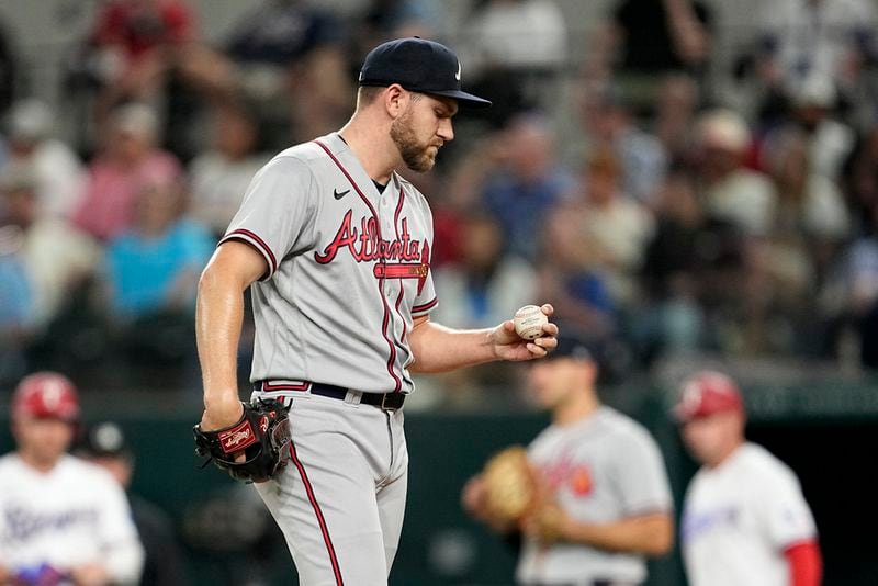 Atlanta Braves relief pitcher Dylan Lee stands on the mound looking at the ball as he works against the Texas Rangers in the seventh inning of a baseball game, Tuesday, May 16, 2023, in Arlington, Texas. (AP Photo/Tony Gutierrez)