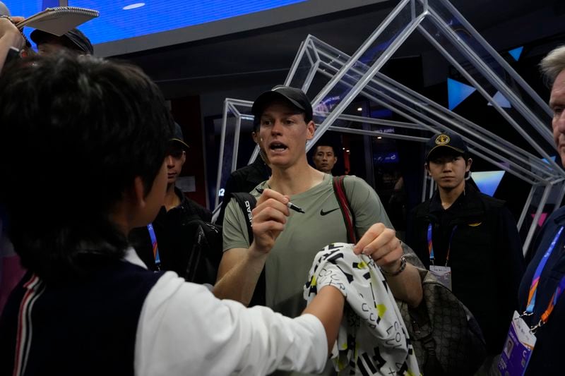 Jannick Sinner of Italy autographs for fans after defeating Roman Safiullin of Russia during the China Open tennis tournament held at the National Tennis Center in Beijing, Saturday, Sept. 28, 2024. (AP Photo/Ng Han Guan)