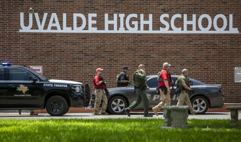 FILE - Law enforcement personnel walk outside Uvalde High School after shooting a was reported earlier in the day at Robb Elementary School, Tuesday, May 24, 2022, in Uvalde, Texas. (William Luther/The San Antonio Express-News via AP)