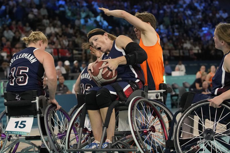 Bo Kramer of the Netherlands (right) and Natalie Schneider of the United States play during the gold medal game in women's wheelchair basketball between the Netherlands and the United States at the 2024 Paralympic Games in Paris, France, Sunday, Sept. 8, 2024. (AP Photo/Christophe Haenah)