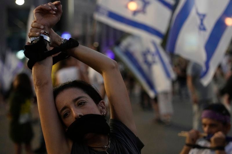 A woman takes part in a protest by relatives of hostages held by Hamas militants in the Gaza Strip and their supporters call for their immediate release and against Israeli Prime Minister Benjamin Netanyahu's government in Tel Aviv, Israel, Saturday, Aug. 17, 2024. (AP Photo/Tsafrir Abayov)