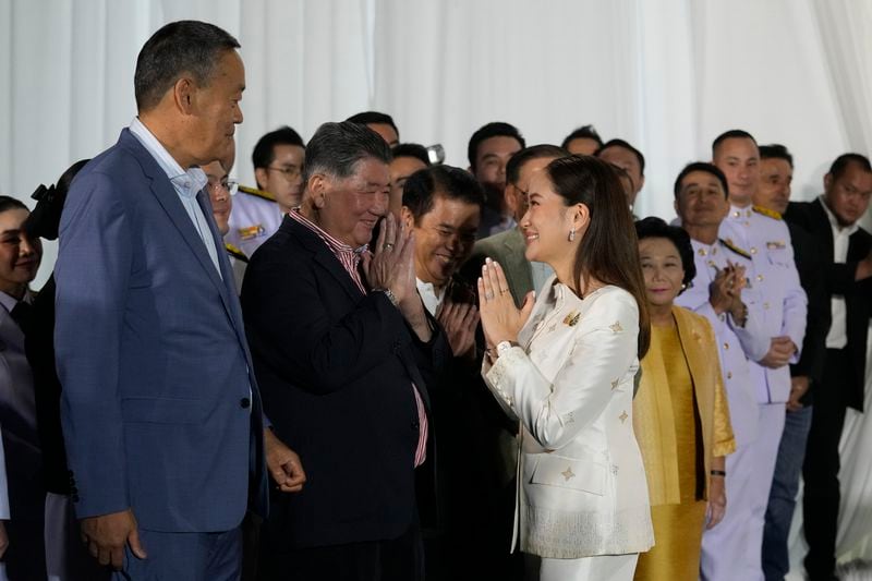 Thailand's new Prime Minister Paetongtarn Shinawatra, right, pays respect to former Thai Prime Minister Srettha Thavisin, left, after receiving the royal endorsement for the post, Sunday, Aug. 18, 2024, at the Pheu Thai party headquarters in Bangkok, Thailand. (AP Photo/Sakchai Lalit)