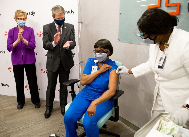 Georgia Gov. Brian P. Kemp and Dr. Kathleen Toomey clap after Grady ICU nurse Norma Poindexter becomes the first health care worker in Georgia to receive her COVID-19 vaccination on Dec. 17. (Steve Schaefer/Atlanta Journal-Constitution/TNS)