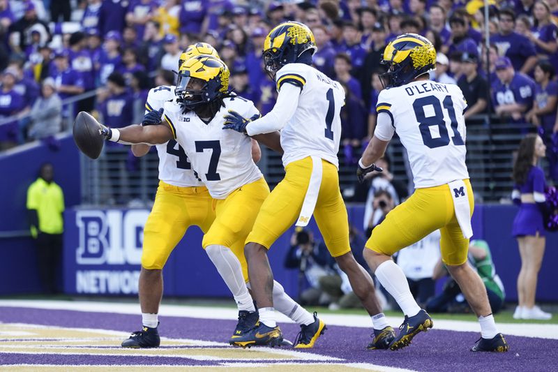 Michigan running back Donovan Edwards (7) reacts with wide receiver Amorion Walker (1) and wide receiver Peyton O'Leary (81) after scoring a touchdown against Washington during the first half of an NCAA college football game Saturday, Oct. 5, 2024, in Seattle. (AP Photo/Lindsey Wasson)