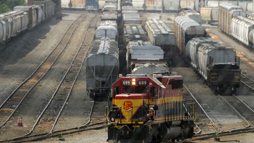 A worker climbs aboard a locomotive at a CPKC rail yard Wednesday, Aug. 21, 2024, in Kansas City, Mo. (AP Photo/Charlie Riedel)