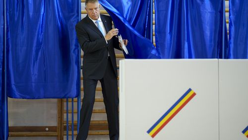 Romanian President Klaus Iohannis exits a voting cabin during European and local elections in Bucharest, Romania, Sunday, June 9, 2024. Voters across the European Union are going to the polls on the final day of voting for the European parliamentary elections to choose their representatives for the next five-year term. (AP Photo/Andreea Alexandru)