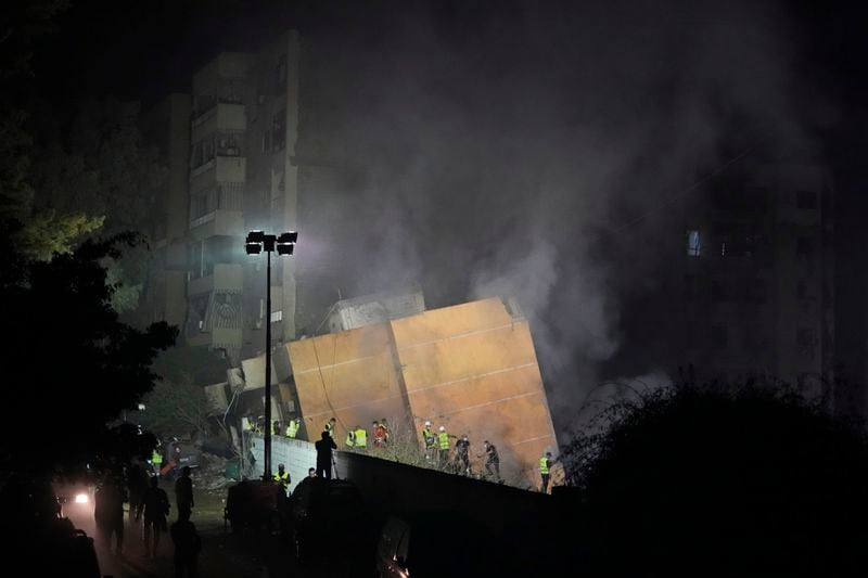 Rescuers arrive at the site of an Israeli airstrike in Beirut's southern suburbs, Friday, Sept. 27, 2024. (AP Photo/Hassan Ammar)