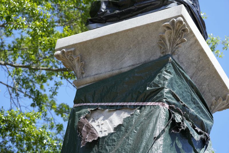 Small sections of the century-old Confederate memorial marble statue are seen underneath the weather-worn tarp covering the monument in Grenada, Miss., April 12, 2023. (AP Photo/Rogelio V. Solis)