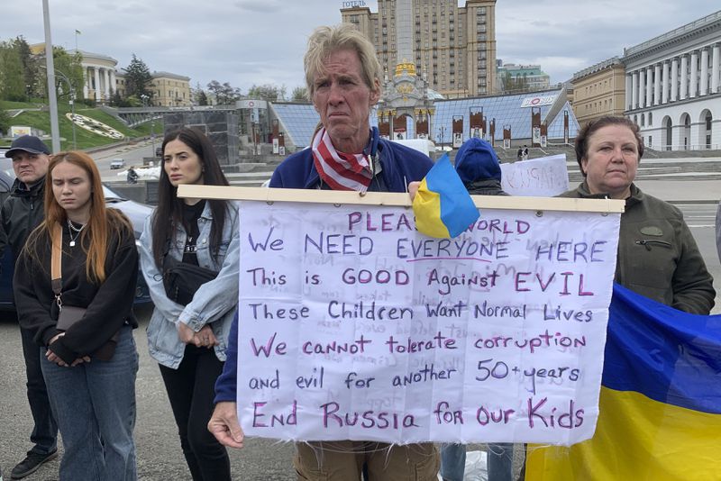 Ryan Wesley Routh holds up a banner during a rally in central Kyiv, Ukraine on Saturday April 30, 2022. (AP Photo/Alex Babenko)