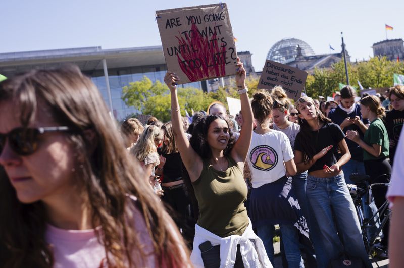 Protestors show placards as they take part in a Global Climate Strike protest of the Fridays For Future' movement near the chancellery in Berlin, Germany, Friday, Sept. 20, 2024. (AP Photo/Markus Schreiber)