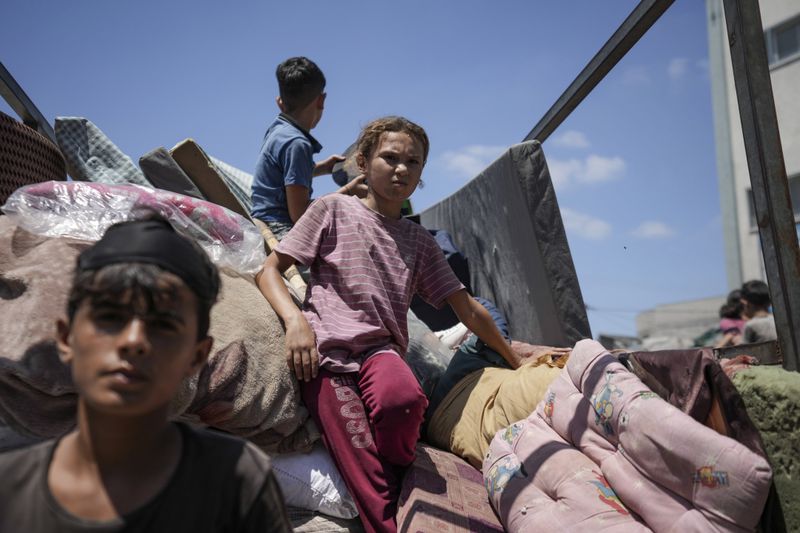 Palestinians evacuate a school that had been their shelter, in eastern Deir al-Balah, Gaza Strip, Friday, Aug. 16, 2024, after the Israeli military dropped leaflets asking civilians to evacuate from the area and northern Khan Younis, saying forces plan to respond to rocket fire that targeted Israel. (AP Photo/Abdel Kareem Hana)