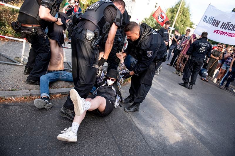 Police officers detain men during a protest against an election party of AfD supporters for the state elections in Saxony and Thuringia, in Berlin, Germany, Sunday, Sept. 1, 2024. (Fabian Sommer/dpa via AP)