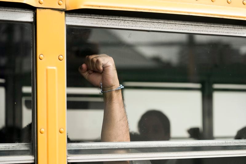 A Nicaraguan citizen raises his fist from a bus after being released from a Nicaraguan jail and landing at the airport in Guatemala City, Thursday, Sept. 5, 2024. (AP Photo/Moises Castillo)