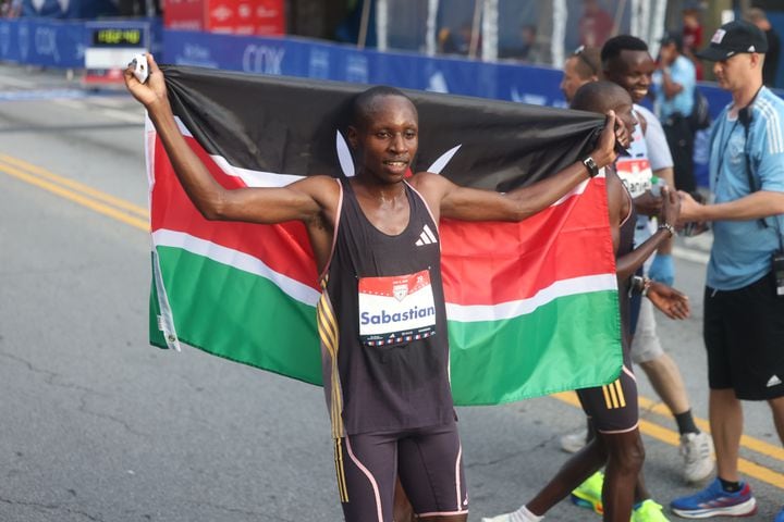 Sebastian Sawe celebrates win at the finish of the 55th running of the Atlanta Journal-Constitution Peachtree Road Race in Atlanta on Thursday, July 4, 2024.   (Jason Getz / AJC)