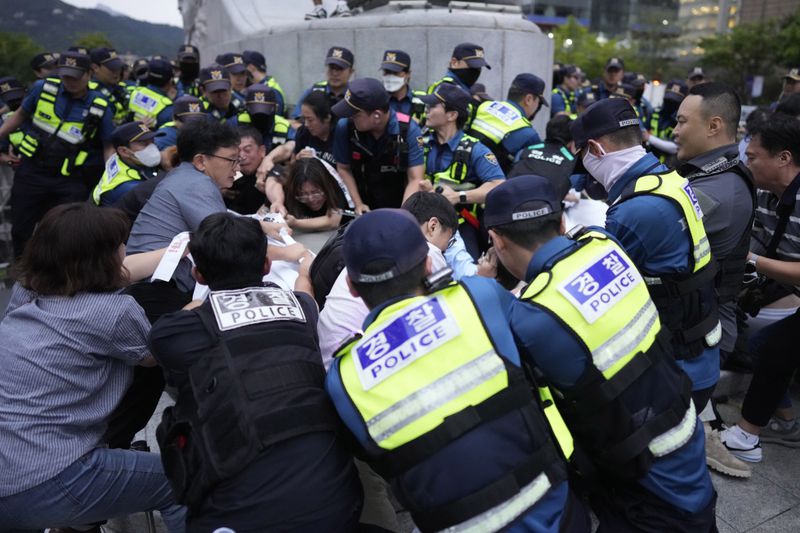 South Korean police officers try to remove a huge banner from protesters during a rally opposing the meeting between South Korean President Yoon Suk Yeol and Japanese Prime Minister Fumio Kishida in Seoul, South Korea, Friday, Sept. 6, 2024. (AP Photo/Lee Jin-man)