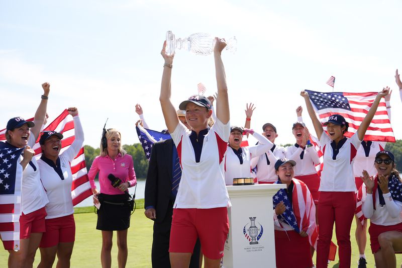 United States Captain Stacy Lewis holds the winner's trophy after the United States won the Solheim Cup golf tournament against Europe at the Robert Trent Jones Golf Club, Sunday, Sept. 15, 2024, in Gainesville, Va. (AP Photo/Matt York)