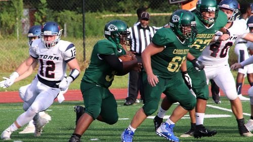 Cross Keys running back Roy Huff (center) looks for yardage behind the blocking of Bryan Guerrero (61) in the Indians' season-opening game against Providence Christian on Aug. 23, 2019, at Adams Stadium in Atlanta.