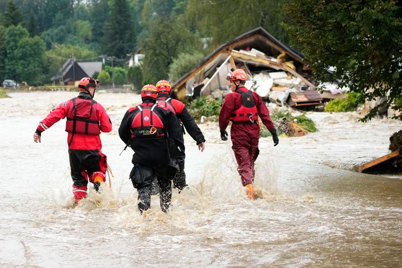 FILE - Firefighters walk through a flooded road of Jesenik, Czech Republic, Sept. 15, 2024. (AP Photo/Petr David Josek, File)