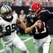 Atlanta Falcons quarterback Kirk Cousins (18) runs out of the pocket against New Orleans Saints defensive end Chase Young (99) during the second half of an NFL football game, Sunday, Sept. 29, 2024, in Atlanta. (AP Photo/Butch Dill)