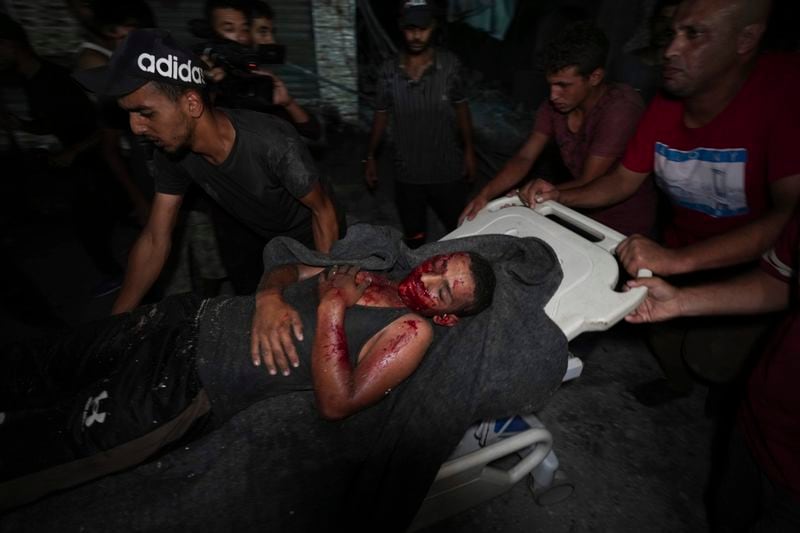 Palestinians carry an injured man from a destroyed mosque following an Israeli airstrike in Deir al-Balah, Sunday, Oct. 6, 2024. (AP Photo/Abdel Kareem Hana)