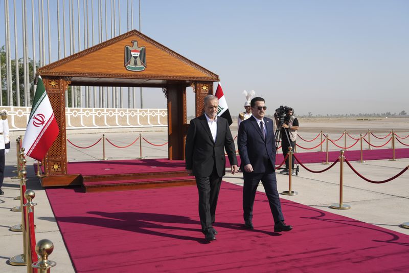 Iranian President Masoud Pezeshkian is welcomed by Iraqi Prime Minister Mohammed Shia al-Sudani, right, with an official ceremony at the Baghdad International Airport in Baghdad, Iraq, Wednesday Sept. 11, 2024. (Murtadha Al-Sudani/Pool Photo via AP)