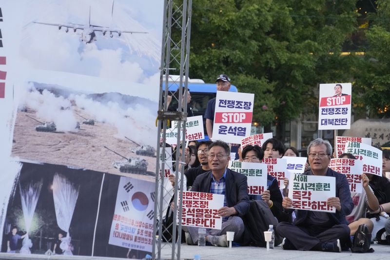 Protesters stage a rally demanding the stop of military exercises and propaganda amid rising tensions between North and South Korea, in Seoul, South Korea, Monday, June 24, 2024. South Korea is monitoring an expected change in the wind direction on Monday that could allow North Korea to send more trash-carrying balloons across their heavily armed border, in their latest bout of tit-for-tat psychological warfare. North Korea threatened Friday to retaliate after a South Korean activists’ group sent balloons carrying anti-North Korean propaganda leaflets across the border. The signs read: "Stop artillery exercise in the West Sea" (AP Photo/Ahn Young-joon)