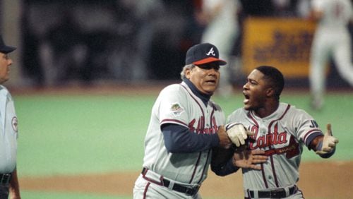 Atlanta Braves first base coach Pat Corrales holds back an angry Ronnie Gant, right, after he was called out on a controversial play during the third inning of Game 2 at the World Series in Minneapolis, Oct. 21, 1991. Gant felt that Minnesota Twins first baseman Kent Hrbek had knocked him off the base. Gant was rule out and the Twins went on to beat the Braves 3-2. (AP Photo/Bill Waugh)