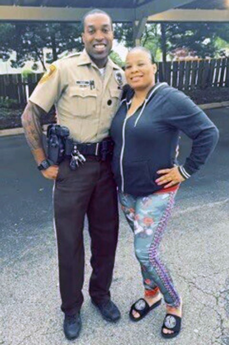 In this undated photo provided by Charlene Jefferson in August 2024, Travis Brown, when he was St. Louis County police officer, stands with Jefferson. Brown, a Ferguson Police officer, suffered a severe brain injury after he was knocked to the ground Friday, Aug. 9, 2024, during a protest in Ferguson, Mo., on the 10th anniversary of the shooting death of Michael Brown. (Courtesy Charlene Jefferson via AP)