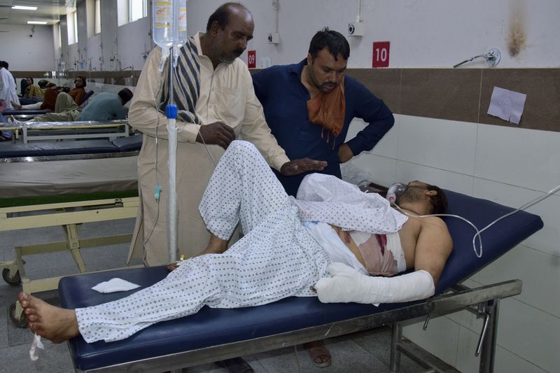 Relatives take care of a passenger, wounded by gunmen at a highway in Musakhail, after receiving initial treatment at a hospital, in Quetta, Pakistan, Monday, Aug. 26, 2024. (AP Photo/Arshad Butt)