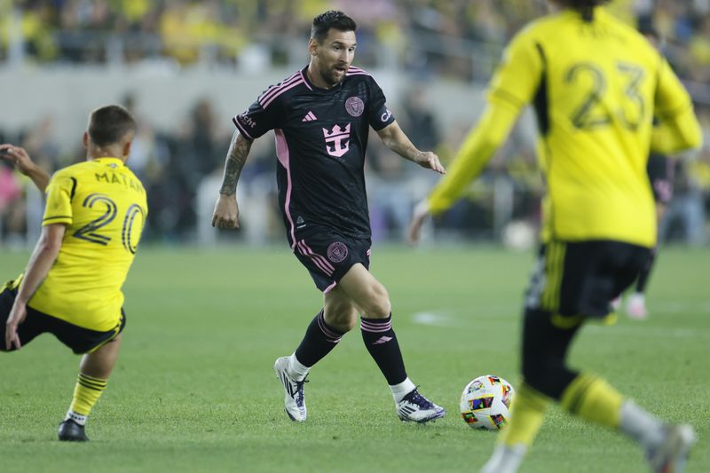 Inter Miami's Lionel Messi, center, tries to dribble between Columbus Crew's Alexandru Matan, left, and Mohamed Farsi during the first half of an MLS soccer match, Wednesday, Oct. 2, 2024, in Columbus, Ohio. (AP Photo/Jay LaPrete)