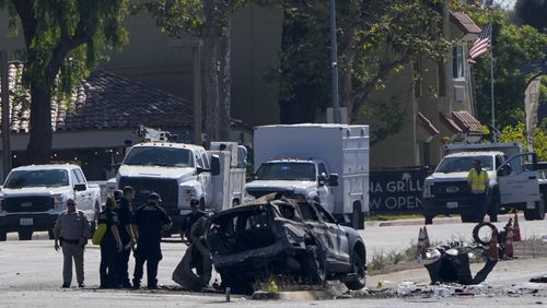 A charred police vehicle is seen in aftermath of an overnight crash which left an officer dead Tuesday, Aug. 27, 2024, in San Diego. (AP Photo/Gregory Bull)