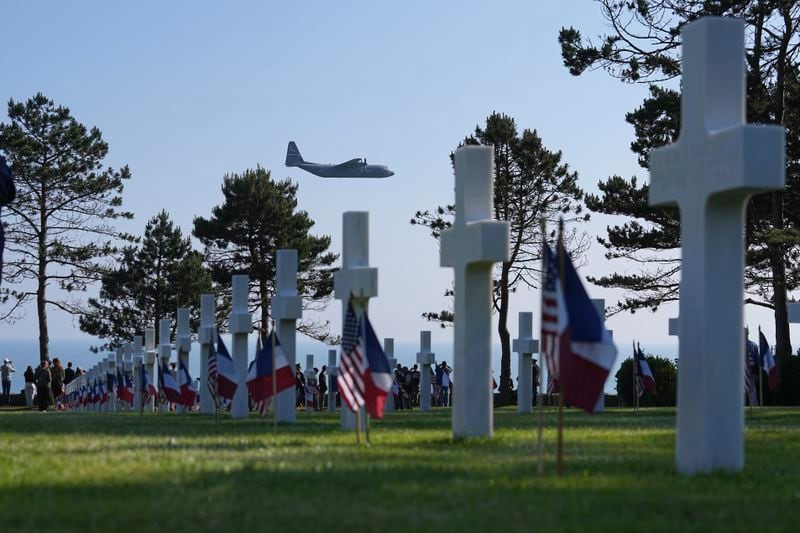 A military plane flies over a U.S. cemetery today near Colleville-sur-Mer in Normandy. 