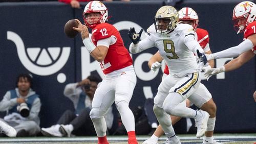 Virginia Military Institute quarterback Chandler Wilson (12) throws under pressure from Georgia Tech defensive lineman Romello Height (9) during the first half of a NCAA college football game Sunday, Sept. 14, 2024, in Atlanta,. (AP Photo/John Bazemore)