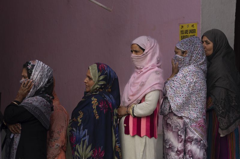 Kashmiri women queue up at a polling booth to cast their vote during the second phase of the assembly election in the outskirts of Srinagar, Indian controlled Kashmir, Wednesday, Sept. 25, 2024. (AP Photo/Dar Yasin)